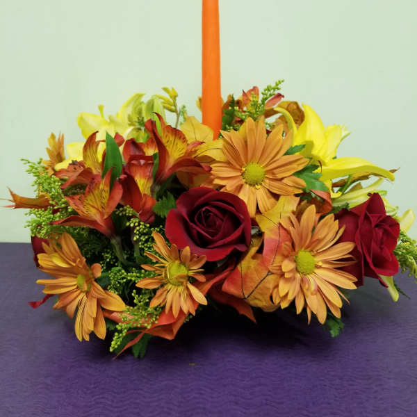 Autumn floral centerpiece with an orange taper candle