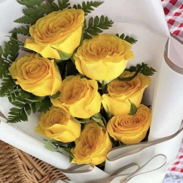 Bouquet of yellow roses wrapped in white paper