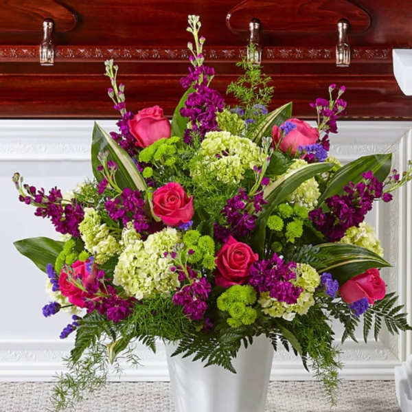 Pink roses and purple flowers in a white vase