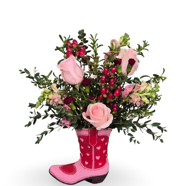 Pink roses and mixed flowers arranged in a pink cowboy boot