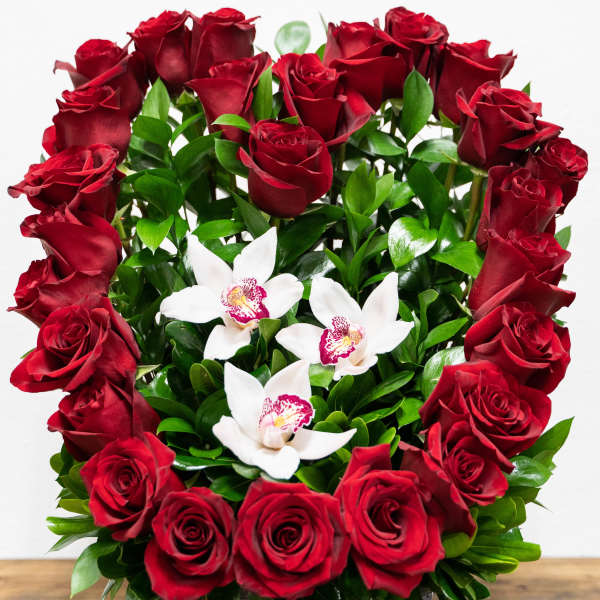 Red roses and white orchids in a square gray container