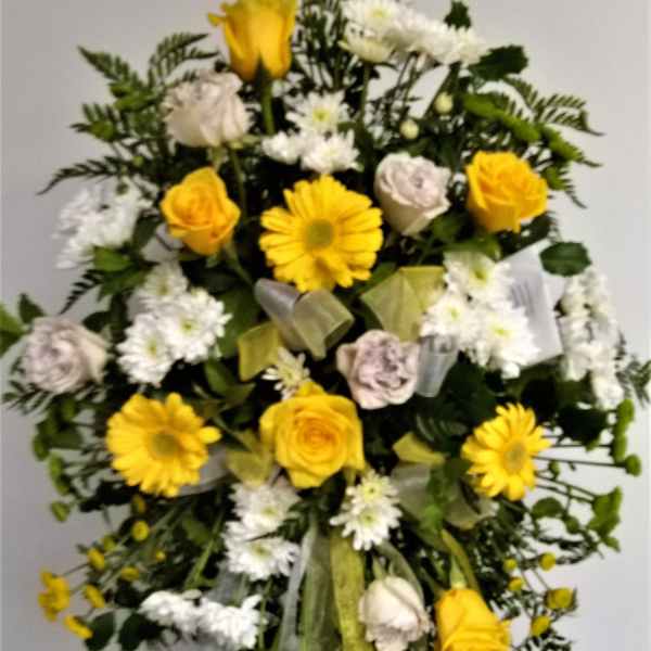 Yellow roses and white daisies in a standing floral spray