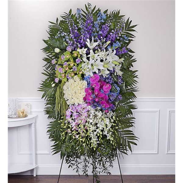 Standing funeral spray with white lilies, orchids, and purple flowers