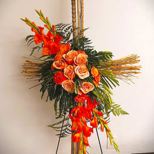 Tall floral arrangement with orange roses and gladiolus on a bamboo stand