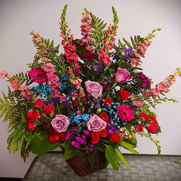 Large mixed bouquet with roses, gerbera daisies, and snapdragons in a basket
