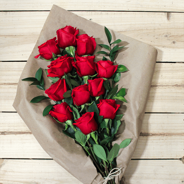 Bouquet of red roses wrapped in brown paper