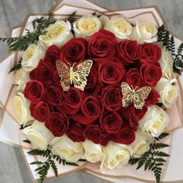 Heart-shaped bouquet of red and white roses with butterfly accents