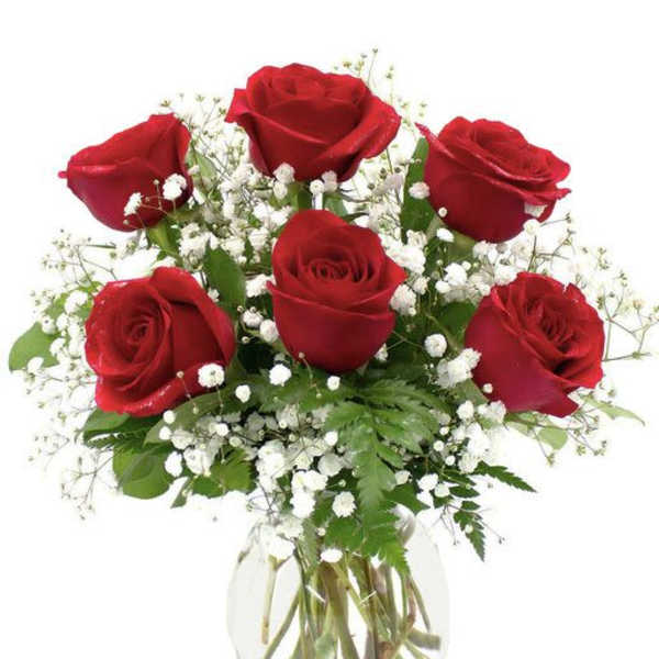 Bouquet of red roses and white baby's breath in a clear glass vase