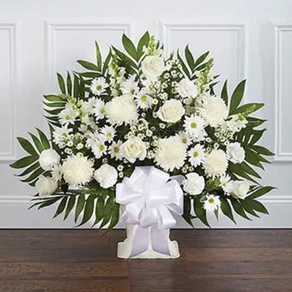 White floral standing spray with a large bow on a white easel