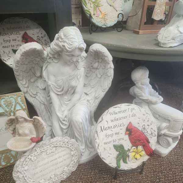 White angel figurines and memorial plaques displayed on shelves