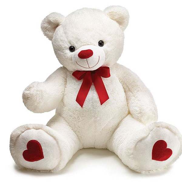 White teddy bear with a red bow and heart-shaped paw pads