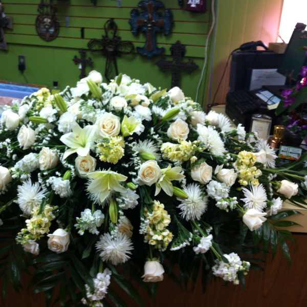 Large white floral casket spray with roses and lilies