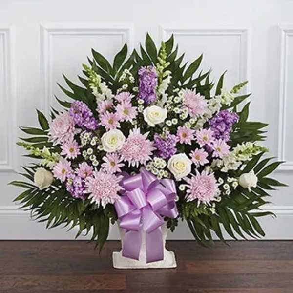 Lavender and white floral standing spray with a purple ribbon bow