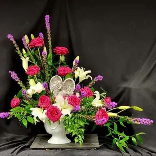 Pink roses and white lilies in a white urn vase