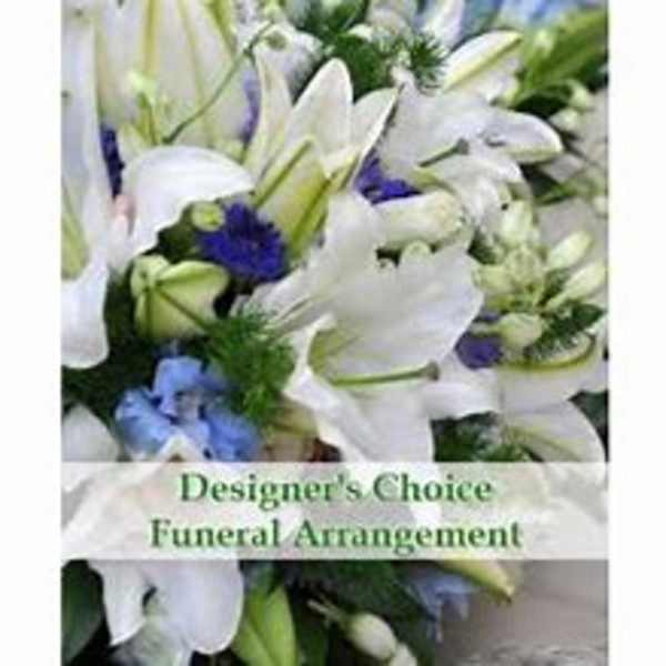 White lilies and blue flowers in a funeral arrangement