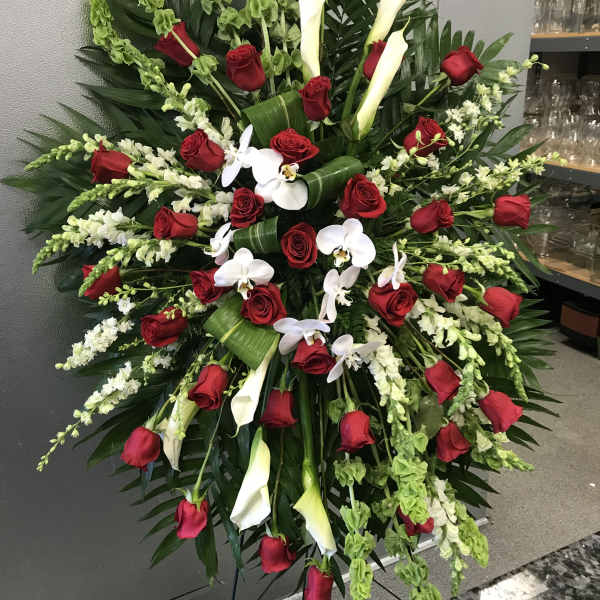 Large standing floral spray with red roses, white calla lilies, and white orchids