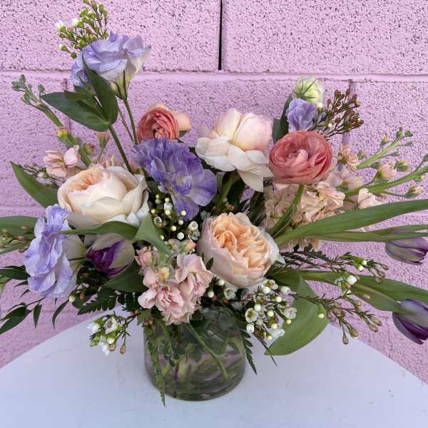 Pastel bouquet of roses, tulips, and lisianthus in a glass vase