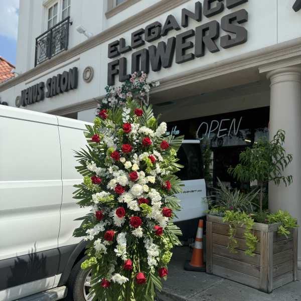 Tall standing floral spray with red and white roses on an easel