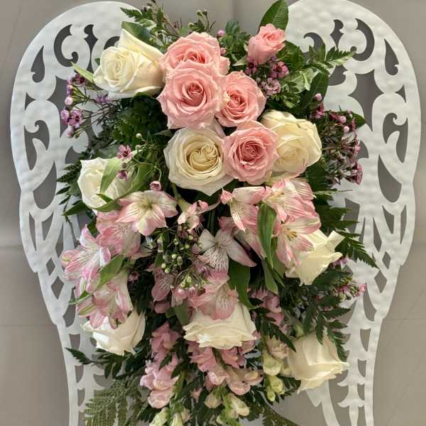 Pink and white rose arrangement on a decorative white stand