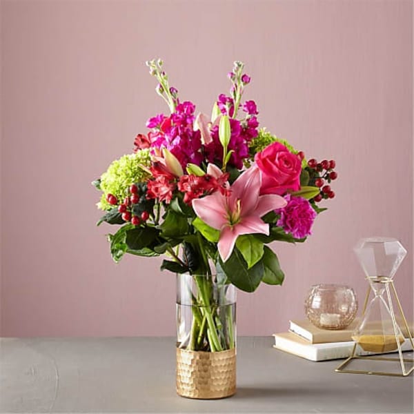 Pink and magenta flower arrangement in a clear glass vase