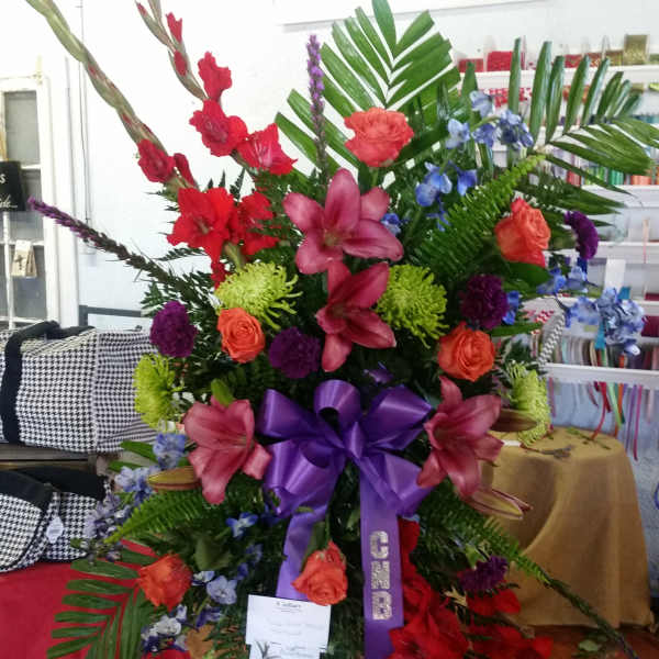 Large standing floral spray with red, pink, purple, and blue flowers