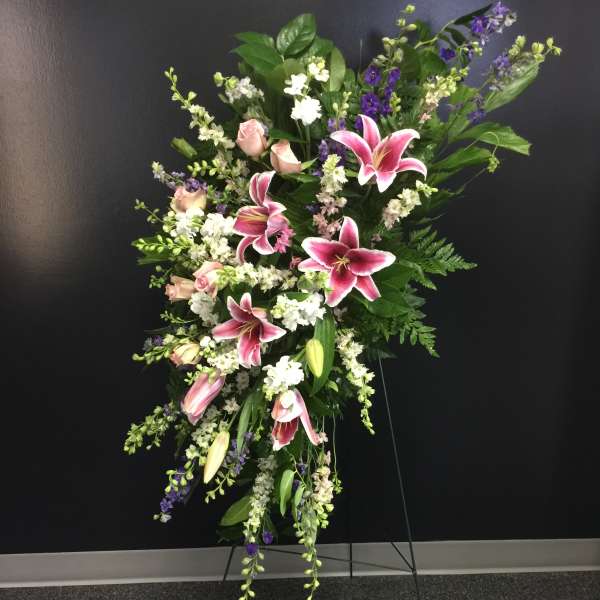 Tall standing floral spray with pink lilies, roses, and purple accents