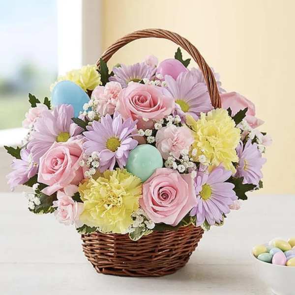 Basket of pastel flowers with decorative eggs