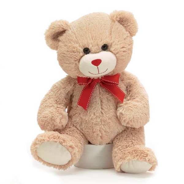 Plush teddy bear with a red ribbon bow