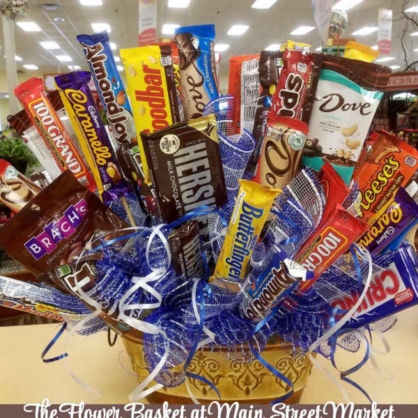 Basket arrangement of assorted candy bars with blue ribbon