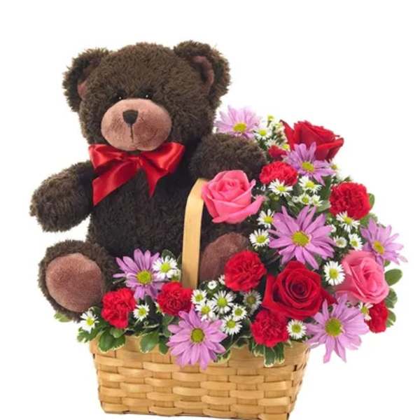 Teddy bear in a basket with pink and red flowers