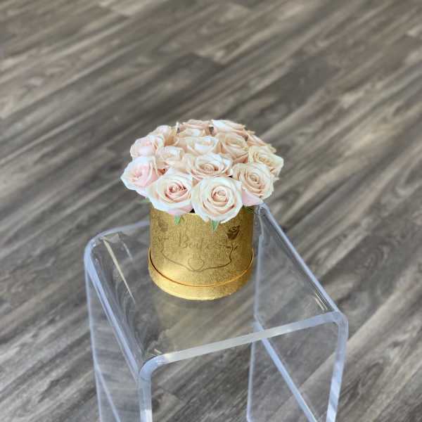 Small bouquet of pale pink roses in a gold round box