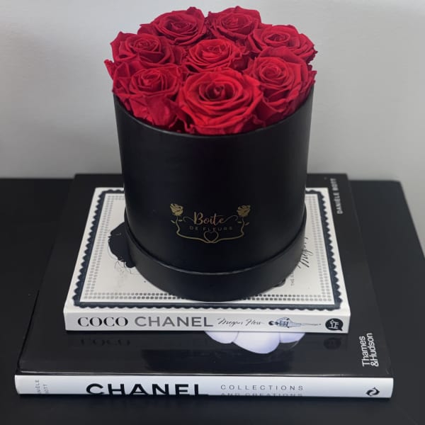 Red roses arranged in a black round box