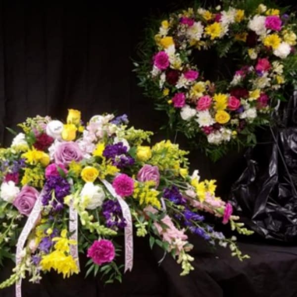 Large mixed floral spray with a matching wreath behind it