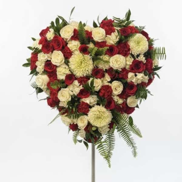 Heart-shaped red and white floral spray on a stand