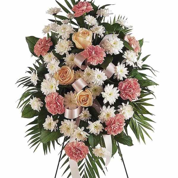 Standing floral spray with pink carnations, white daisies, and peach roses