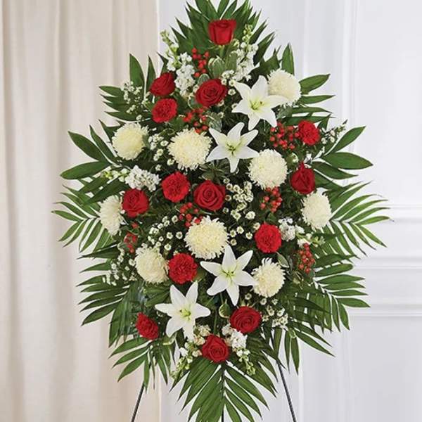 Standing floral spray with red roses, white lilies, and white pompons