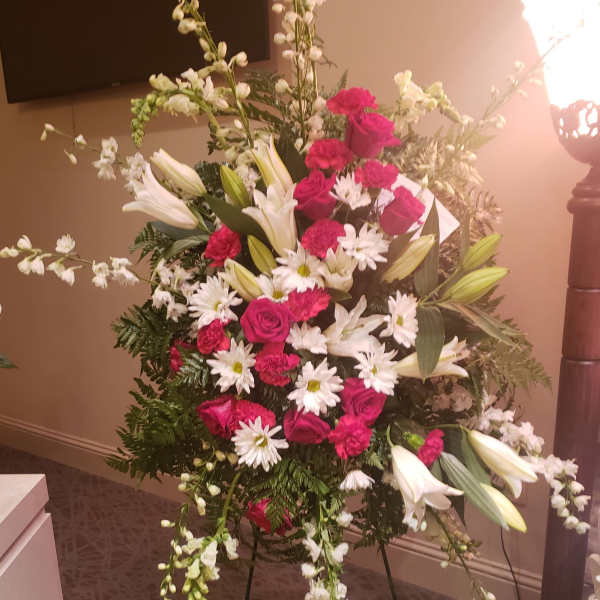 Standing floral spray with pink roses, white lilies, and daisies