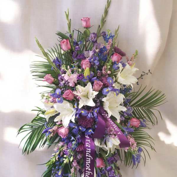 Purple and pink floral spray with white lilies and roses