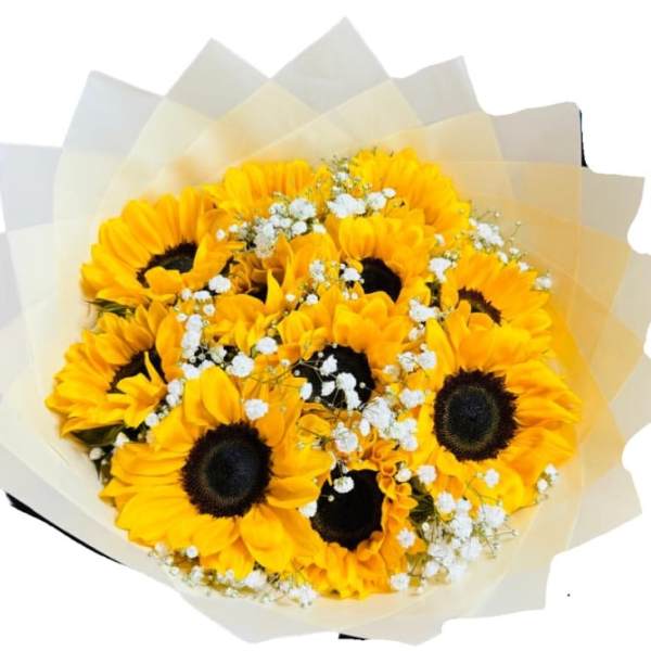 Hand-tied bouquet of bright yellow sunflowers with white filler flowers in cream paper wrap