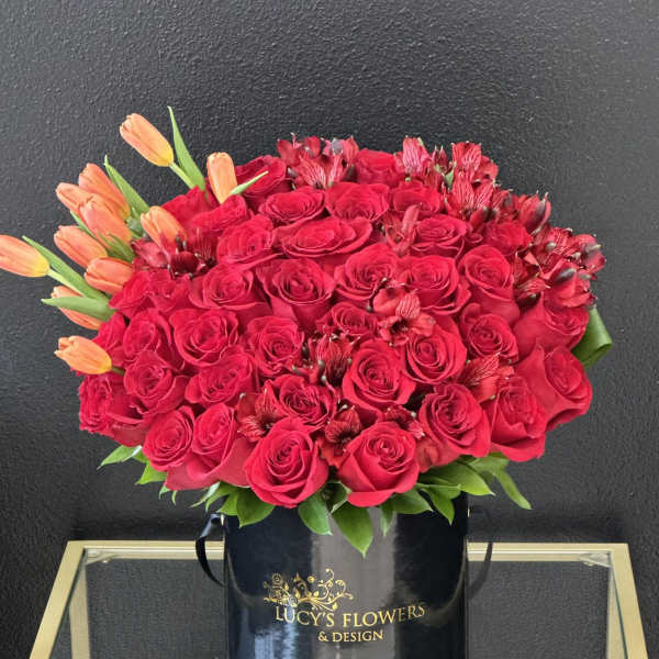 Red rose bouquet with orange tulips in a black hatbox
