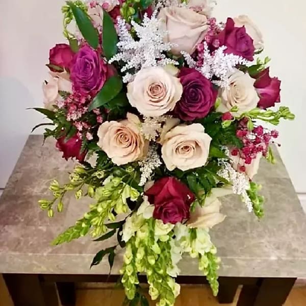 Bouquet of cream and magenta roses with white filler flowers