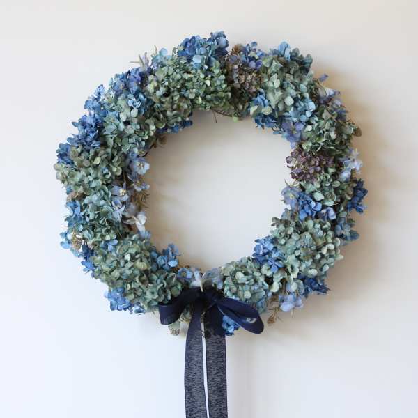 Blue dried flower wreath with a dark ribbon bow