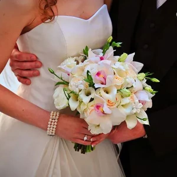 Bride and groom holding a white and blush wedding bouquet