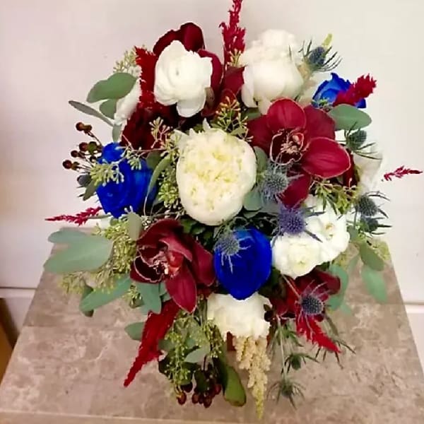 Bouquet of red, white, and blue flowers with eucalyptus accents
