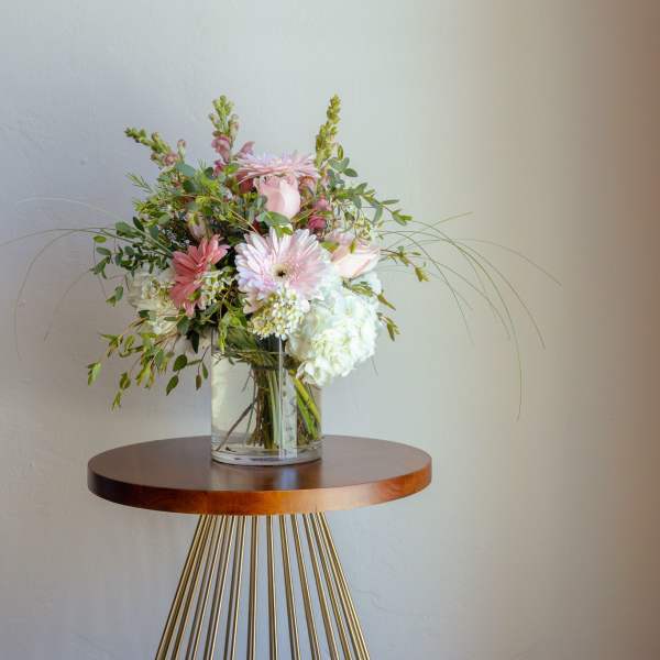 Pink and white flower arrangement in a clear glass vase