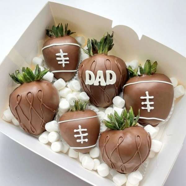 Box of chocolate-covered strawberries decorated like footballs and one with "DAD"