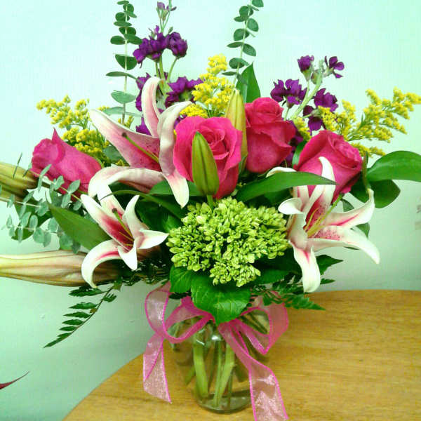 Bouquet of pink roses and white lilies in a glass vase