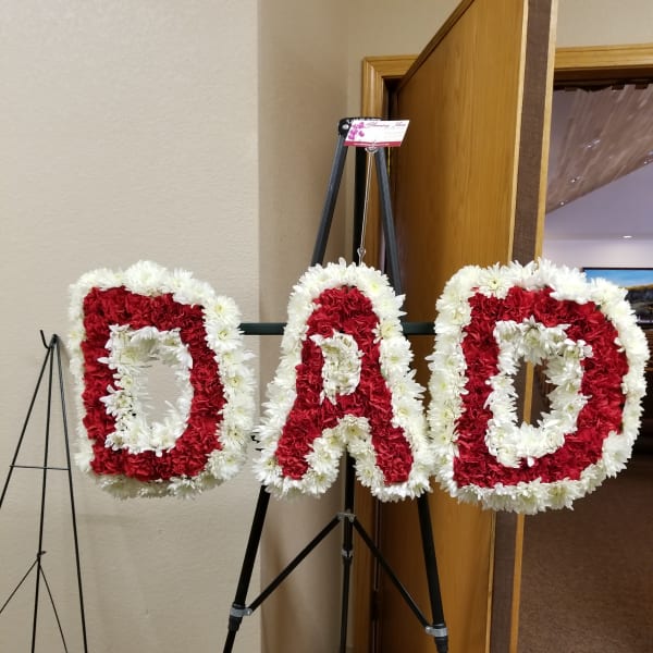 Floral standing letters spelling DAD in red and white flowers