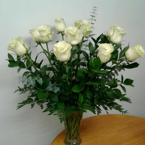 White roses arranged in a clear glass vase