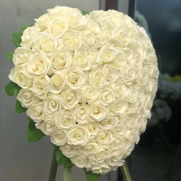 Large heart-shaped bouquet of white roses on a stand